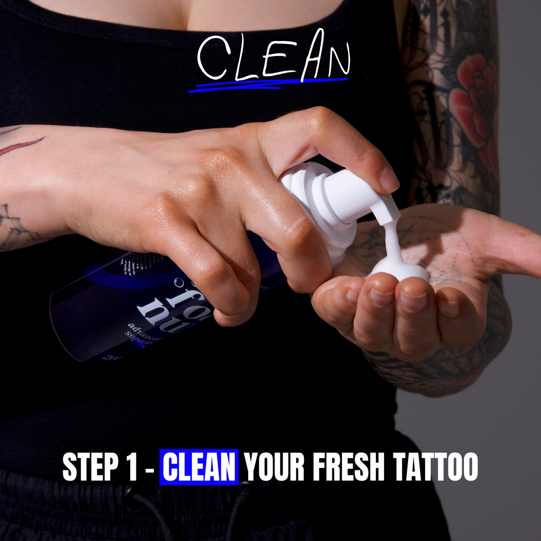 A person with tattooed arms pumps white foam from a blue ink nurse tattoo soap foam wash bottle called foam nurse into their hand, with text overlays reading 'CLEAN' and 'STEP 1 - CLEAN YOUR FRESH TATTOO' for a crucial step in cleaning a fresh tattoo in the tattoo aftercare healing journey.